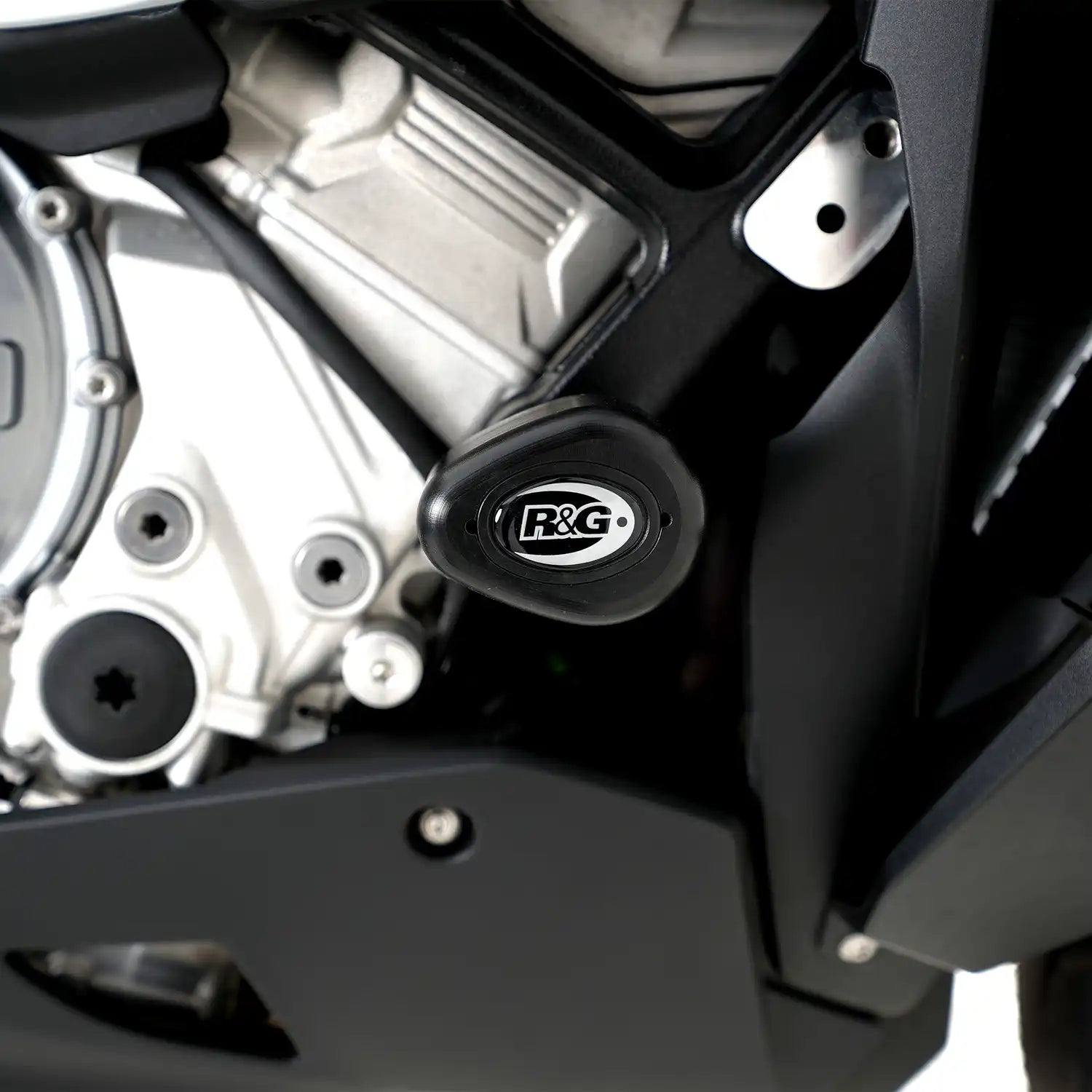Detalle bobbin blanco R&G en M1000XR 2024 mostrando forma aerodinámica y acabado premium