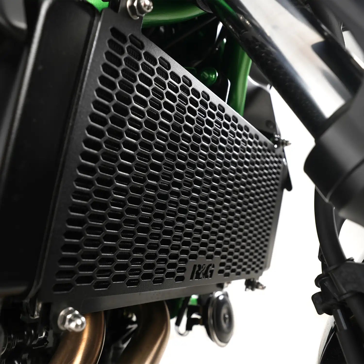 Vista lateral protector radiador R&G montado en Ninja 650 mostrando calce OEM