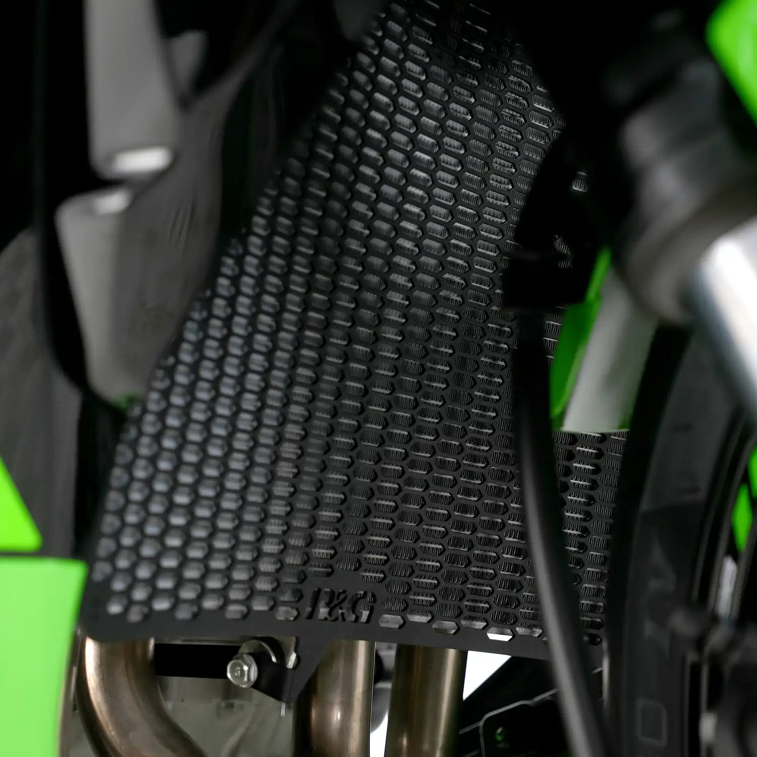 Protector de Radiador R&G PRO montado en Kawasaki ZX-6R 2024 negro, vista frontal mostrando patrón hexagonal laser-cut