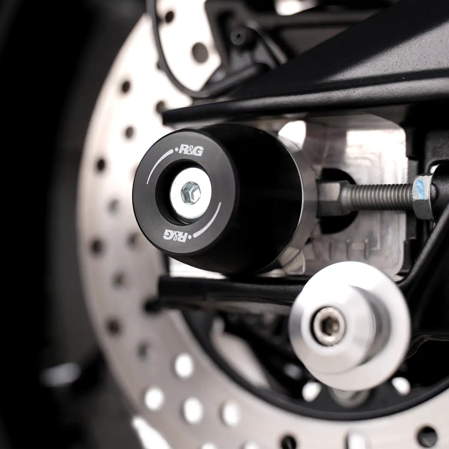 Vista lateral topes de eje R&G APEX en Aprilia Tuono 660 Factory 2025